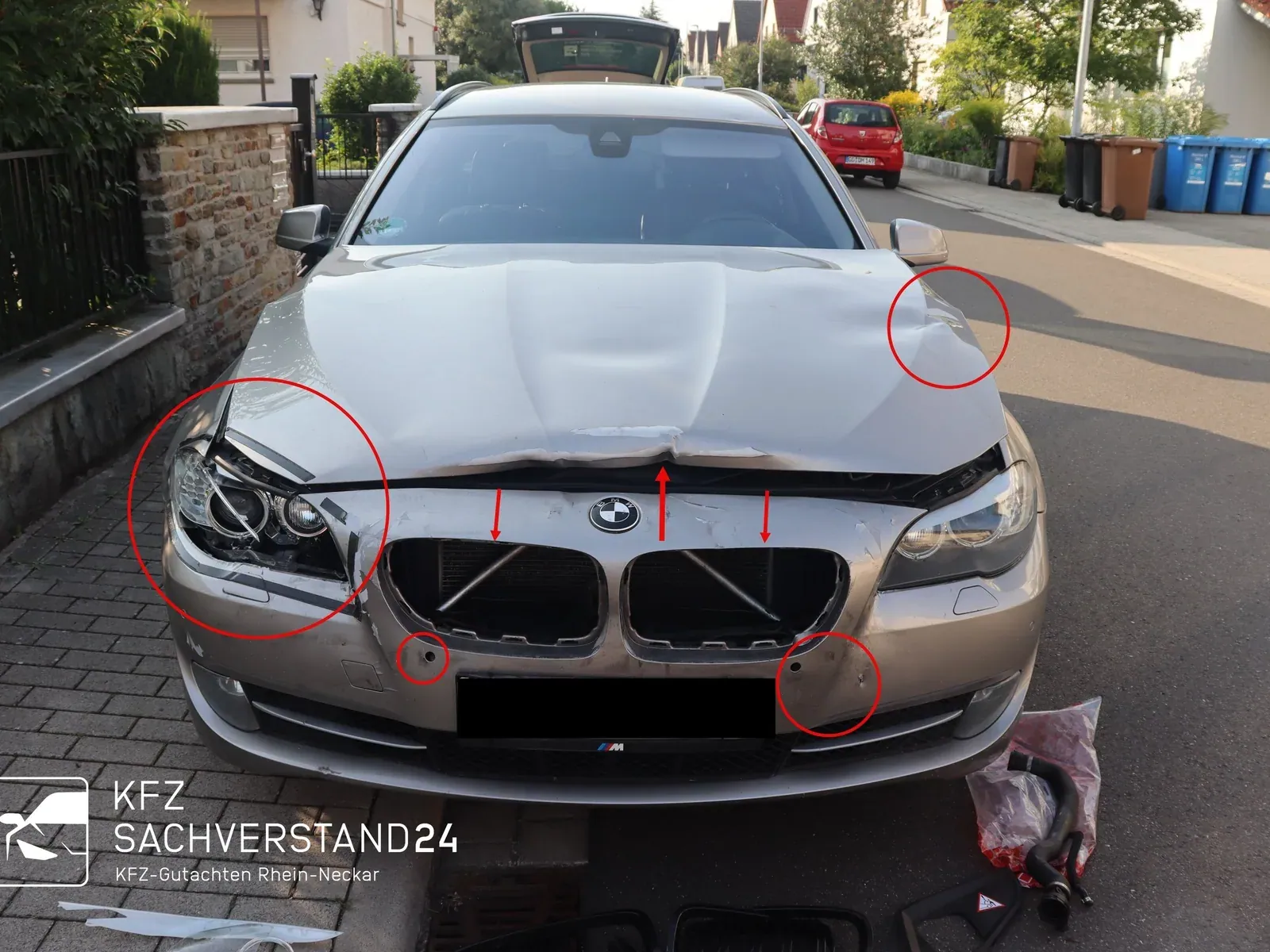 BMW 5er Touring mit Frontschaden: markierte Schäden an Scheinwerfer, Motorhaube und Stoßfänger bei der Begutachtung vor Ort