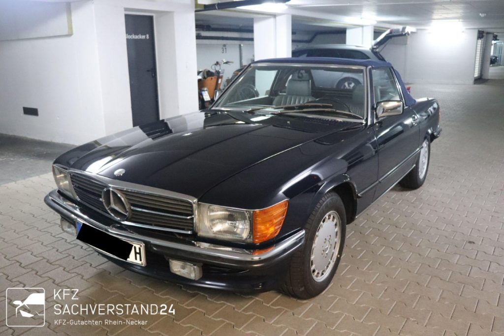 Schwarzer Mercedes-Benz Oldtimer mit offenem Dach in einer Parkgarage abgestellt.